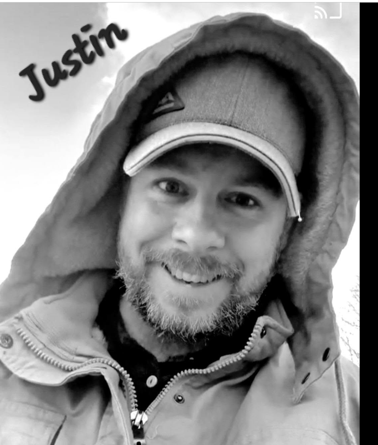 Justin smiling in a hooded jacket, with his name at the upper left.