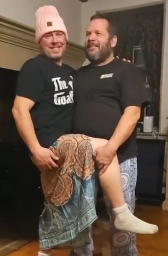 Jeff and a friend sharing a playful pose indoors.